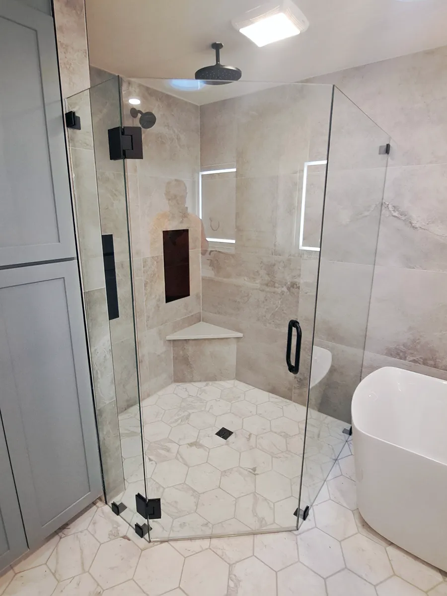 Custom neo-angle frameless shower enclosure with matte black hardware and glass-to-glass hinges installed in Roswell, GA