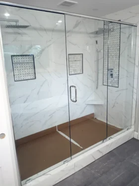 Three-piece inline frameless shower door with chrome top header and center door in Atlanta, GA.